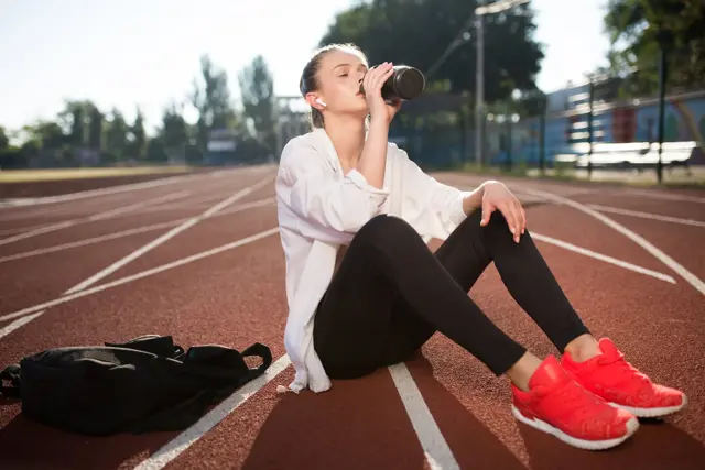 Beautiful Girl Wireless Earphones Drinking Pure Water While Spending Time Running Track Stadium